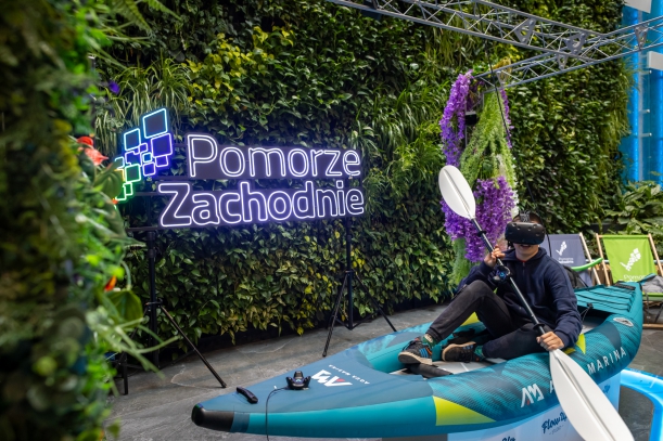 Uczestnik festynu na desce SUP w googlach VR