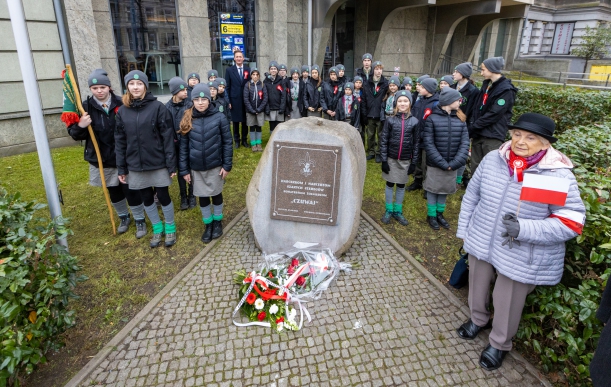Uroczystość z okazji Narodowego Święta Niepodległości 2022 w Szczecinie. Marszałek województwa Olgierd Geblewicz i kilkudziesięciu harcerzy pozuje do pamiątkowego zdjęcia po złożeniu kwiatów przy obelisku Szarych Szeregów.