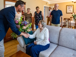 Marszałek Geblewicz wręcza bukiet kwiatów jubilatce. 