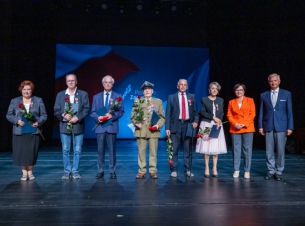 Spotkanie z kombatantami i opozycjionistami w Teatrze Polskim w Szczecinie. Na scenie Przewodnicząca Sejmiku Teresa Kalina, Członek Zarządu Województwa Stanisław Wziątek, dwie uhonorowane odznakami kobiety i czterech mężczyzn (jeden w mundurze).