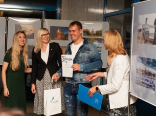 Wernisaż wystawy "Otwarte Pomorze Zachodnie. Oczami Imigrantów" w Książnicy Pomorskiej w Szczecinie. Członkini Zarząd Województwa Zachodniopomorskiego Anna Bańkowska rozmawia z trzema osobami - organizatorami wystawy i autorami zdjęć.